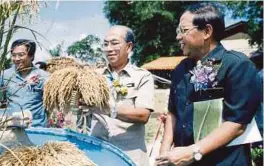  ??  ?? Sanusi ketika menjadi Menteri Pertanian melihat padi jenis MR123 dan MR127 yang diperkenal MARDI di Besut, Terengganu.