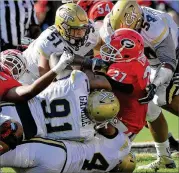  ?? HYOSUB SHIN / HSHIN@AJC.COM ?? Nick Chubb (buried by Georgia Tech defenders) and other Georgia players haven’t forgotten last year’s loss. “The last game didn’t go how any of us wanted,” he said. “It kind of hurt inside.”