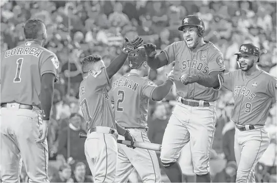  ?? Karen Warren / Houston Chronicle ?? George Springer, second from right, was the man of the moment Wednesday night after his tw0-run, second inning home run put the Astros up 5-0 in Game 7.