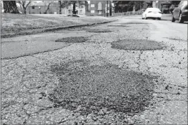  ?? [JOSHUA A. BICKEL/DISPATCH] ?? In cold weather, crews are only able to make temporary fixes by filling potholes. The temperatur­e needs to be well above freezing for the hot asphalt to properly bind to existing pavement.