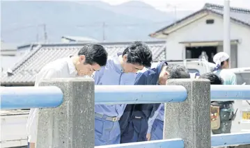  ?? REUTERS ?? Japan’s Prime Minister Shinzo Abe, second from left, pays a silent tribute to the victims of torrential rain at Nomura, Japan.