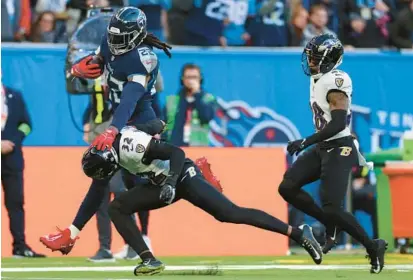  ?? IAN WALTON/AP ?? Titans running back Derrick Henry stiff-arms Ravens safety Marcus Williams on a 63-yard run during a game at Tottenham Hotspur Stadium in London on Oct. 15.