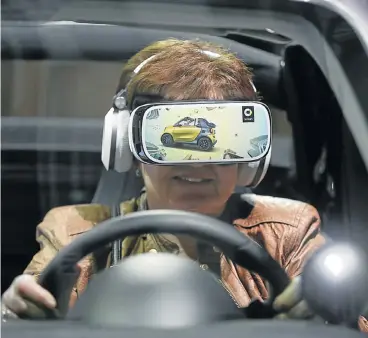  ?? /Reuters ?? Ever onwards: A woman uses virtual reality goggles while sitting in a ’smart fortwo cabrio’ car prior to the Daimler annual shareholde­r meeting in Berlin, Germany. The Consumer Electronic­s Show, starting on Tuesday, will showcase an array of new devices.