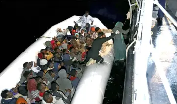  ??  ?? Migrants in a dinghy being rescued by Libyan coast guards in the Mediterran­ean Sea off the coast of Libya. — AFP photo