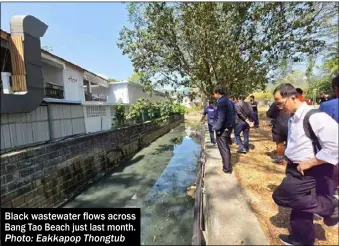  ?? Photo: Eakkapop Thongtub ?? Black wastewater flows across Bang Tao Beach just last month.