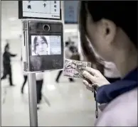  ?? Bloomberg News/ QILAI SHEN ?? An employee uses a facial recognitio­n device as she swipes her badge to enter the assembly line area at a Pegatron Corp. factory in Shanghai in mid- April.