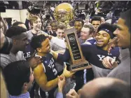  ?? Brian A. Pounds / Hearst Connecticu­t Media ?? Yale players raise the championsh­ip trophy at center court following their 97-85 victory over Harvard in the Ivy League men’s final Sunday in New Haven.