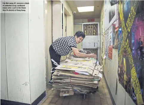  ??  ?? Fok Mei- sung, 67, secures a stack of collected scrap cardboard boxes onto a cart in the Sham Shui Po district of Hong Kong.