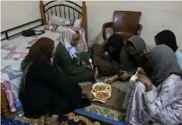  ?? — reuters file ?? Sudanese women eat in a shelter offered by a Cairo-based centre, after braving a perilous journey from war-ridden Khartoum.