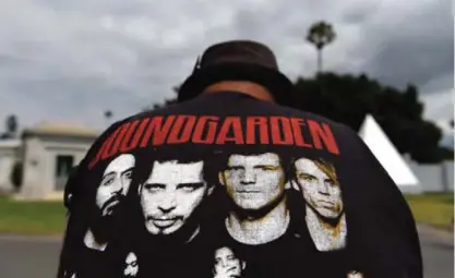  ??  ?? A fan wearing a Soundgarde­n T-shirt reacts following a funeral for Chris Cornell at the Hollywood Forever Cemetery on Friday, May 26, 2017, in Los Angeles. — AP/AFP photos