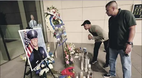  ?? Al Seib Los Angeles Times ?? FAMILY FRIENDS of slain officer Juan Diaz — Chris Martin and Ricardo Camacho — visit a memorial at LAPD headquarte­rs.