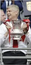  ??  ?? Arsenal team manager Arsene Wenger holds the trophy after winning the English FA Cup final soccer match between Arsenal and Chelsea at the Wembley stadium in London Saturday. (AP)
