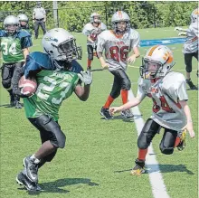  ??  ?? St. Catharines back Dahari Williams, left, is defended by Niagara Falls in atom championsh­ip action on Super Sunday in St. Catharines.