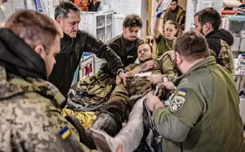  ?? ?? A Ukrainian soldier with a bullet wound to his leg is treated at a stabilizat­ion point near a front line in the Donetsk region of Ukraine on Jan. 8.