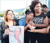  ??  ?? Nicholas Francis’ mother, Petrona Hamilton (second left), is consoled by members of the Jamaica College Parent-Teacher Associatio­n.