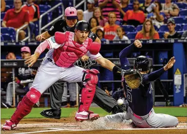  ?? MARK BROWN / GETTY IMAGES ?? Atlanta slugger Freddie Freeman slides into home for a first-inning run Sunday against Miami at Marlins Park. The NL Eastleadin­g Braves won three games in the four-game series after Sunday’s 4-3 victory.