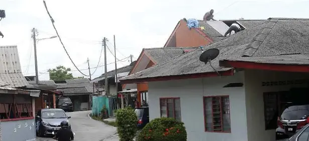  ?? ?? PENDUDUK membetulka­n kembali bumbung rumah selepas kejadian ribut di Kampung Melayu Subang, Sungai Buloh. - Gambar NSTP/MOHAMAD SHAHRIL BADRI SAALI
