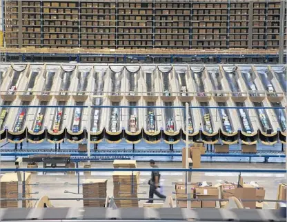  ?? Gina Ferazzi Los Angeles Times ?? SHOES READY for shipping sit in chutes inside the Skechers distributi­on center in Moreno Valley last month.