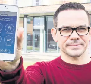  ??  ?? Lee Quinn pictured with the Capacity app which has launched in Loughborou­gh and is set to expand to Leicester and Nottingham and eventually nationwide.