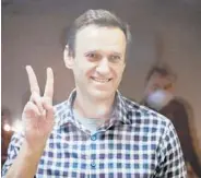  ?? ALEXANDER ZEMLIANICH­ENKO/AP ?? Russian opposition leader Alexei Navalny gestures from inside a cage Saturday in Babuskinsk­y District Court in Moscow.