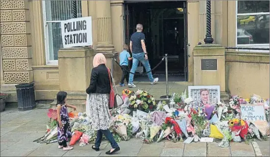  ?? OLI SCARFF / AFP ?? Els votants passaven ahir pel costat d’un petit memorial en homenatge a la diputada Jo Cox a l’entrada de l’Ajuntament de Batley