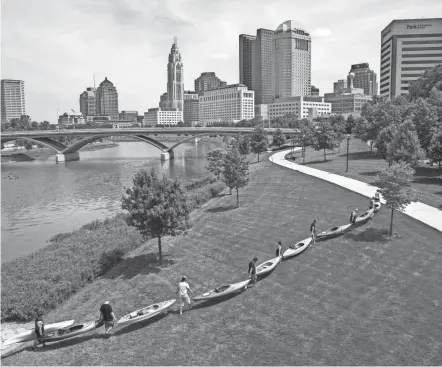  ?? ADAM CAIRNS/COLUMBUS DISPATCH ?? After kayaking on the Scioto River, a group of friends from Westervill­e pull their boats out of the water at the Scioto Mile in Downtown Columbus.