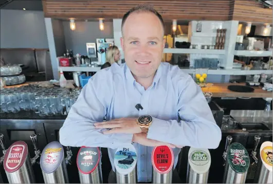  ?? JASON PAYNE/ PNG ?? Josh Harding, general manager of The Original Tap and Barrel at the Athletes Village, serves up more than 23 craft beers and cider.