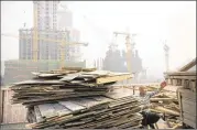  ?? MARK SCHIEFELBE­IN / ASSOCIATED PRESS ?? A worker tosses boards onto the back of a truck at a constructi­on site in Beijing earlier this month. China admits economic growth is slowing, but some say the downturn is deeper than Beijing admits.