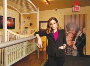  ?? AP PHOTO/LANCE MURPHEY ?? Lisa Marie Presley stands next to her childhood crib displayed with other mementos in the exhibit “Elvis Through His Daughter’s Eyes,” at Graceland in 2012 in Memphis. Lisa Marie Presley, singer and only child of Elvis, died Thursday. She was 54.
