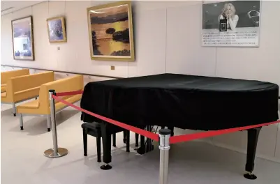  ?? The Yomiuri Shimbun ?? The piano donated by American pop star Cyndi Lauper is displayed at Ishinomaki Municipal Hospital in Miyagi Prefecture, with a picture of Lauper hanging on the wall behind it.