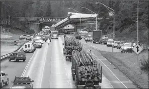  ?? AP/ELAINE THOMPSON ?? Amtrak cars block traffic Monday on Interstate 5 in DuPont, Wash., after part of the train derailed from an overpass onto the highway below.