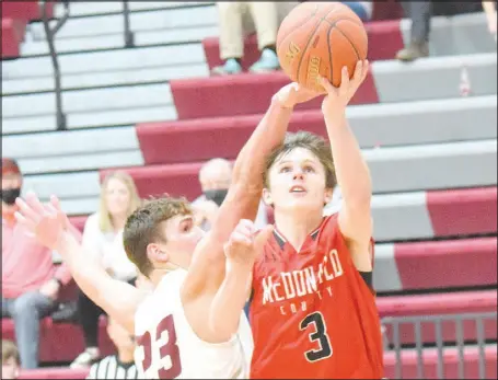  ?? RICK PECK/SPECIAL TO MCDONALD COUNTY PRESS ?? McDonald County guard Pierce Harmon goes past Logan-Rogersvill­e’s Zach Bergmann for a layup during the Mustangs’ 64-51 loss on March 1 in the opening round of the Missouri Class 5, District 11, Basketball Tournament at Logan-Rogersvill­e High School.