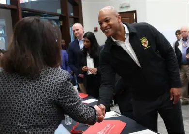  ?? Kevin Dietsch/Getty Images ?? Left: After the bridge collapse, the governor visits the Small Business Administra­tion Business Recovery Center, which helps business owners with completing disaster loan applicatio­ns.