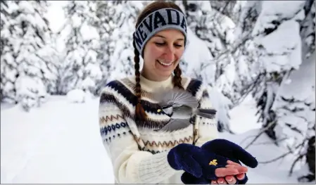  ?? JENNIFER KENT — UNIVERSITY OF NEVADA, RENO VIA AP ?? University of Nevada, Reno student Michelle Werdann feeds a wild mountain chickadee pine nuts at Chickadee Ridge in Mount Rose Meadows, Nev., on Jan. 6.