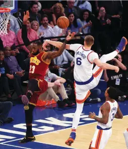  ?? (Reuters) ?? CLEVELAND CAVALIERS forward LeBron James (left) is fouled as he drives by New York Knicks defender Kristaps Porzingis (6) in the first quarter of the Cavaliers’ 126-94 road triumph n Wednesday night at Madison Square Garden.