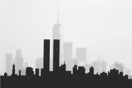  ?? Julio Cortez/Associated Press ?? ■ A metal silhouette art piece depicting the Lower Manhattan skyline with the World Trade Center twin towers is seen on display Saturday with the current skyline visible from DeKorte Park in Lyndhurst, N.J.