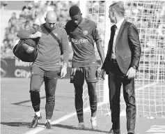  ??  ?? Barcelona’s record signing Ousmane Dembele leaves the pitch after sustaining an injury during a Spanish La Liga match against Getafe at Colisseum Alfonso Perez stadium in Getafe, Spain. — Reuters photo