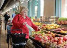  ?? SUBMITTED PHOTO ?? A woman shopping in the produce department of a grocery store. People who are overweight often must learn to like healthy foods.