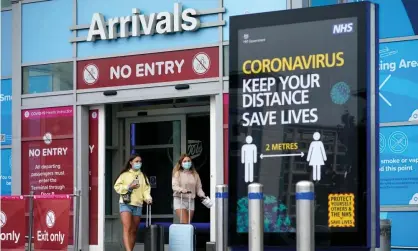  ?? Photograph: Christophe­r Furlong/Getty Images ?? Passengers wearing protective masks leave the arrivals terminal at Birmingham airport.