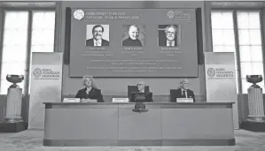  ?? JONATHAN NACKSTRAND/AFP VIA GETTY IMAGES ?? Frenchman Alain Aspect (from left, on wall), American John F. Clauser and Austrian Anton Zeilinger were recognized by the Nobel Committee for Physics on Tuesday in Stockholm.