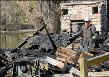  ?? PETE BANNAN- DIGITAL FIRST MEDIA ?? Gary Seaton surveys the remains of his Brandywine Creek retreat home which was destroyed by fire late Saturday night.