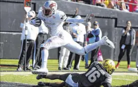  ?? Mike Strasinger The Associated Press ?? UNLV running back Charles Williams leaps over Vanderbilt cornerback BJ Anderson for a 5-yard touchdown in the Rebels’ 34-10 victory Saturday in Nashville, Tenn.