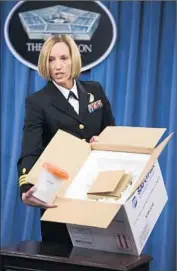  ?? Jim Watson AFP/Getty Images ?? DEFENSE OFFICIAL Franca Jones demonstrat­es at a Pentagon news briefing how anthrax is typically shipped to labs around the country and beyond.