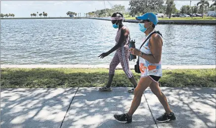  ?? TAMARA LUSH/AP ?? Eva Johnson, left, and Liz Cillo walk by the waterfront Wednesday in St. Petersburg, Fla. Cillo, 72, feels the president hasn’t shown empathy toward seniors.