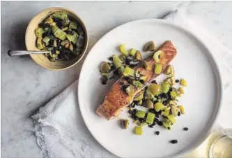  ?? ANDREW SCRIVANI NYT ?? Pan-seared salmon with celery, olives, capers and currants.