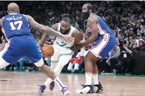  ?? ?? Boston Celtics guard Jaylen Brown (7) drives to the basket between Philadelph­ia 76ers guard James Harden, right, and forward P.J. Tucker (17) Wednesday during the first half of an NBA basketball game in Boston. (AP photo/Charles Krupa)