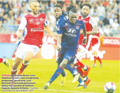  ?? - Gambar oleh RANCOIS NASCIMBENI / AFP ?? PEMAIN pertahanan Reims Yunis Abdelhamid (kiri) cuba menghalang pergerakan penyerang Lyon Bertrand Traoré pada pertemuan kedua-dua pasukan di Stadium Auguste Delaune di Reims.