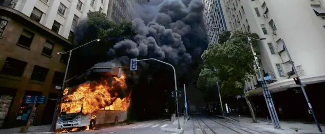  ?? Ricardo Moraes/Reuters ?? Ônibus é incendiado no centro do Rio em protesto contra pacote de medidas que serão votadas pela Assembleia do Rio em contrapart­ida a socorro financeiro do governo federal