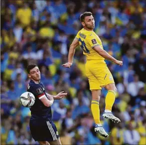  ?? Scott Heppell / Associated Press ?? Ukraine’s Oleksandr Karavayev, right, duels for the ball with Scotland’s Andrew Robertson during the World Cup 2022 qualifying playoff match on Wednesday.