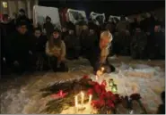  ?? SERGEI CHUZAVKOV — THE ASSOCIATED PRESS ?? A woman lights a candle in honor of the Ukrainian soldiers killed in eastern Ukraine on Independen­ce Square in Kiev, Ukraine, Friday. Fighting between Russian-backed rebels and the government in Kiev has surged in the last month in eastern Ukraine.